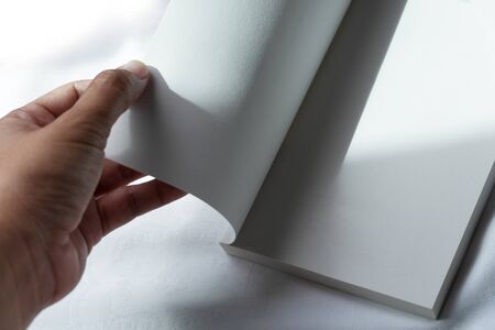 woman hand open empty book or notebook with morning sunlight for education or business backgroundの写真素材