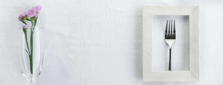 silver fork in white wood frame with natural purple flower in glass for food restaurant service...