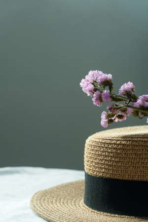 sunlight summer brown hat with nature purple flower on blue grey backgroundの写真素材