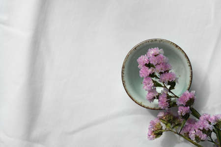 small purple flower with ceramic tea for drink on white backgroundの写真素材