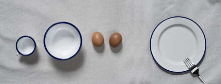 top view of egg white dish bowl and cup for food in drink on natural cotton fabric banner background