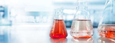 red orange glass flask in blue research chemistry science banner laboratory background