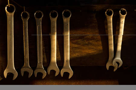 metal wrench on dark wood board for repair or fixing in industrial or home maintenanceの写真素材