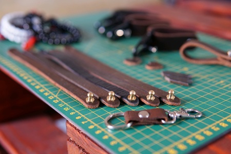 Leather crafts on green crafting board.の素材