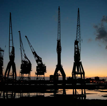 Silhouette of some verry old cranes againt sunset sky in Antwerp, Belgiumの写真素材