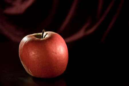 Isolated apple fruit on a reddish black backgroundの写真素材