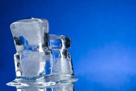An ice cube on a reflective surfaceの写真素材