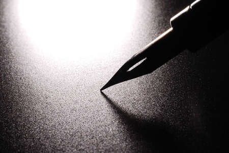 A nib from a dip pen over blackの写真素材