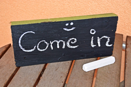 come in writen on a board with chalkの写真素材