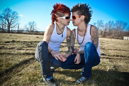 Two young women crouching in a fieldの写真素材