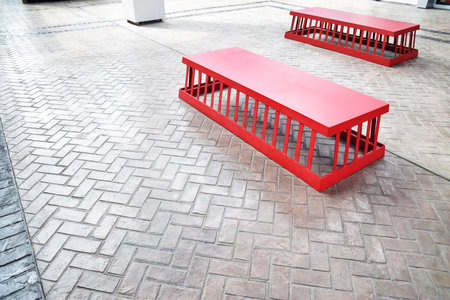 Red metal bench at meeting point at market for customer to rest them leg, meeting or waiting for...