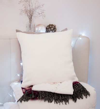 Pillow case Mockup. White pillow on bed in cozy bedroom. Holidays decorations.