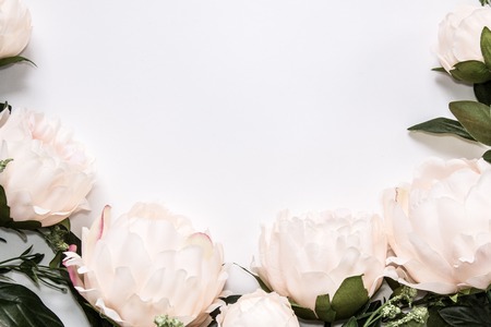 Light pink faux peony flowers around white background with copy space for your text or design, flat top view.の写真素材