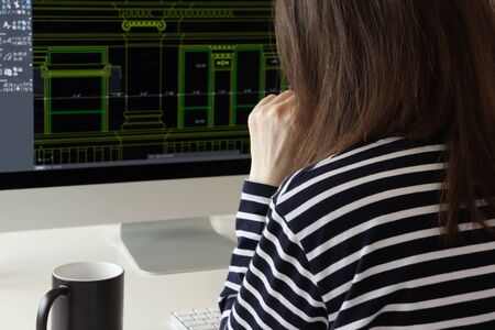 Young female architect works on the project at a computer. Drawing on the screen, working process