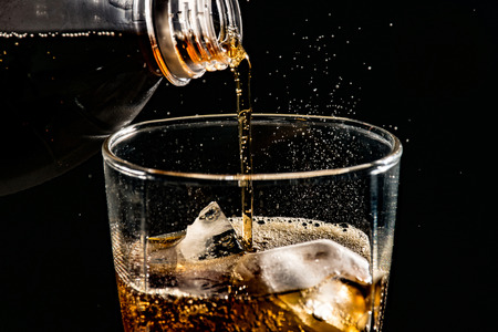 poured beverrage into a glass with ice,Cola drink is fizzy
