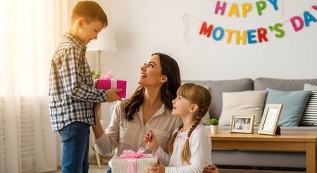 Children surprise mom with gifts on Mother's Day in a joyful home setting.の素材