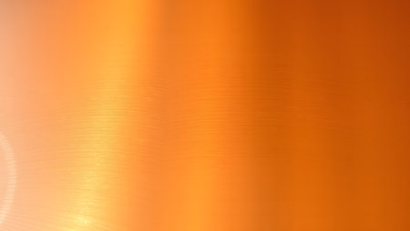 Warm orange gradient abstract background with subtle texture and glow.の素材