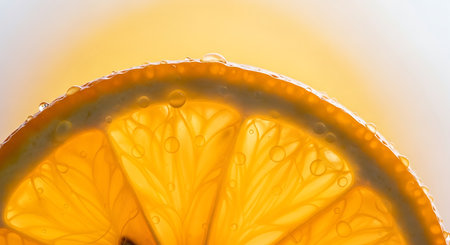 Close up of a slice of orange with water droplets on itの素材