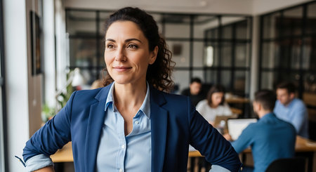 portrait of smiling businesswoman looking at camera while standing in officeの素材