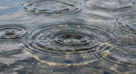 Water drops on the surface of the water. Shallow depth of field.の素材