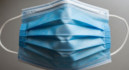 Blue medical mask on a gray background, close-up, macroの素材