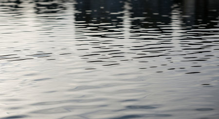 Water surface with ripples and reflections of buildings in the water.の素材