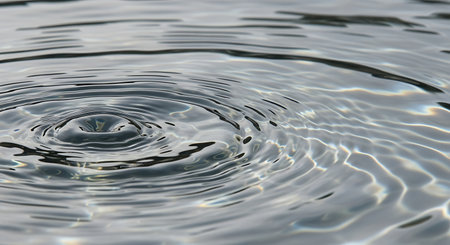 Water drop close up with ripples and waves on the surface.の素材