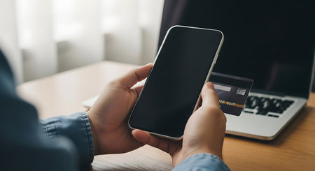 Cropped image of woman using smart phone with blank screen and credit card for online shopping.の素材