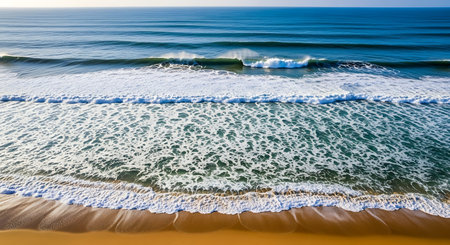 Aerial view of ocean wave on sandy beach at sunset time.の素材