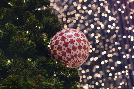 Christmas ball decoration hanging on festive xmas tree with bokeh out of focus background lights - Close up of decorative bauble ornament with copy space - seasonal, christmassy and holidays conceptの写真素材