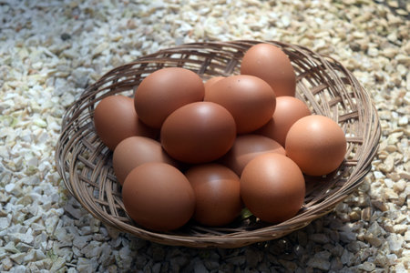 Eggs in a wicker basket on a stone background.の写真素材