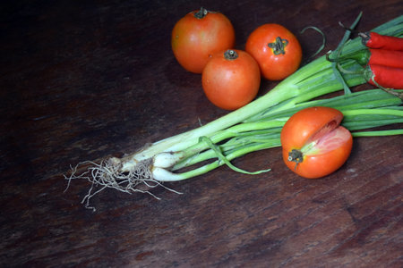 Vegetables on a wooden table. Onions, tomatoes and garlicの写真素材