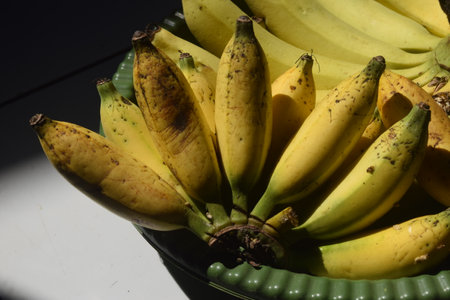 Bunch of bananas in a bowl on a black background. Selective focus.の写真素材