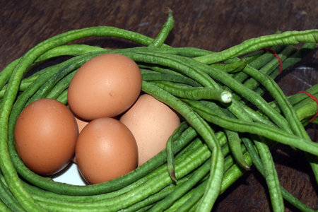 Green beans and eggs on the wooden table, closeup of photoの写真素材