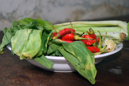 Thai herbs and spices in a bowl on a wooden table.の写真素材