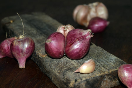 red onions on a wooden cutting board on a rustic background.の写真素材