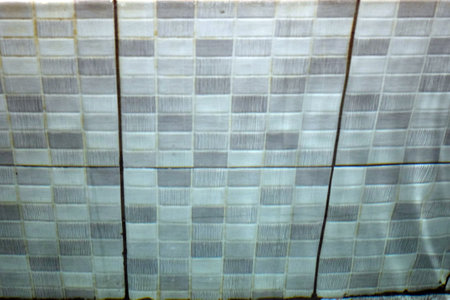 Close-up of a mosaic tile wall. The tiles are white.の写真素材