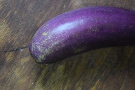 Purple eggplant on wooden background, close-up, selective focusの写真素材
