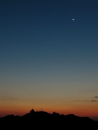 Corcovado and the statue of Christ the Redeemer silhouetted against a beautiful sunset sky and under...