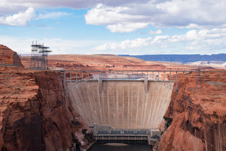 Stunning view of Glen Canyon Dam situated in Page, Arizona with Vehicles Driving Over. The image...