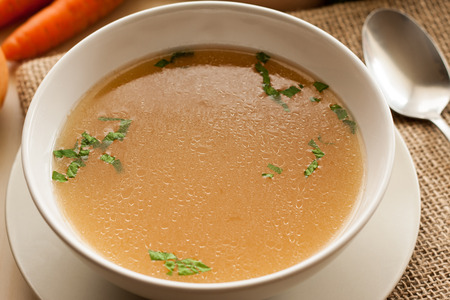 Bone broth made from chicken, served in a bowl with parsleyの写真素材