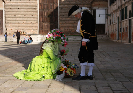 A woman with flowers and a man in costumes at the Venice carnival. Venice, Italy, 5th March 2011のeditorial素材