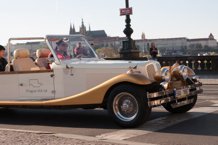 PRAGUE, CZECH REPUBLIC - APRIL 24, 2017: Vintage car taking tourists for a tour in the streets of Prague, with Prague Castle in the backgroundのeditorial素材