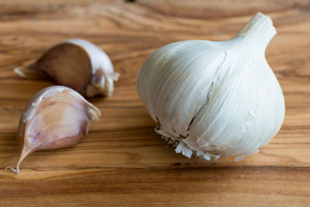 A head of garlic on a wooden background.の写真素材