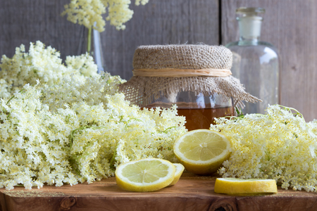 Fresh elder flowers on a wooden background with honey and lemonの写真素材