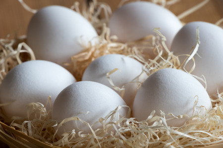 Fresh white eggs in a wicker basket.の写真素材