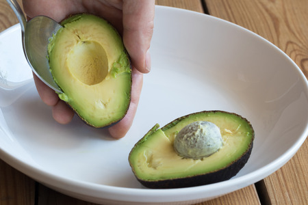 Removing the skin from a ripe avocado.の写真素材