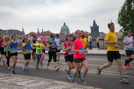 PRAGUE, CZECH REPUBLIC - MAY 7, 2017: Runners at the Prague International Marathon running across a bridge, with the Old Town in the backgroundのeditorial素材