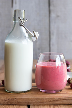 Goats milk kefir with strawberries on a wooden backgroundの写真素材