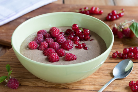 Summer breakfast - raw breakfast bowl with raspberries and red currantsの写真素材